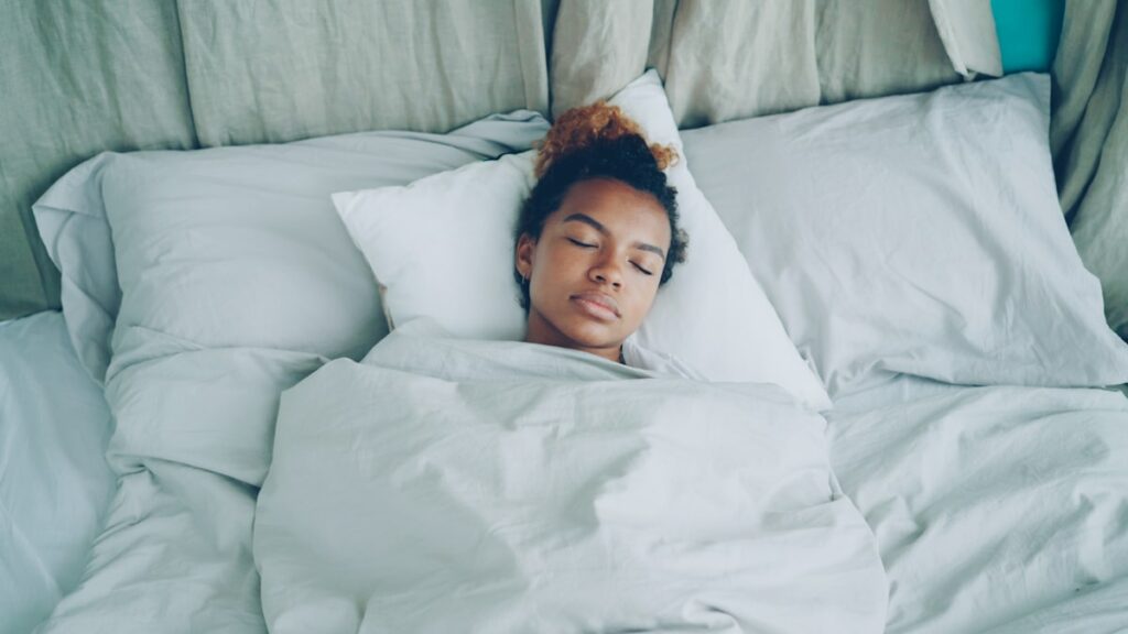 Woman sleeping peacefully in bed for muscle recovery