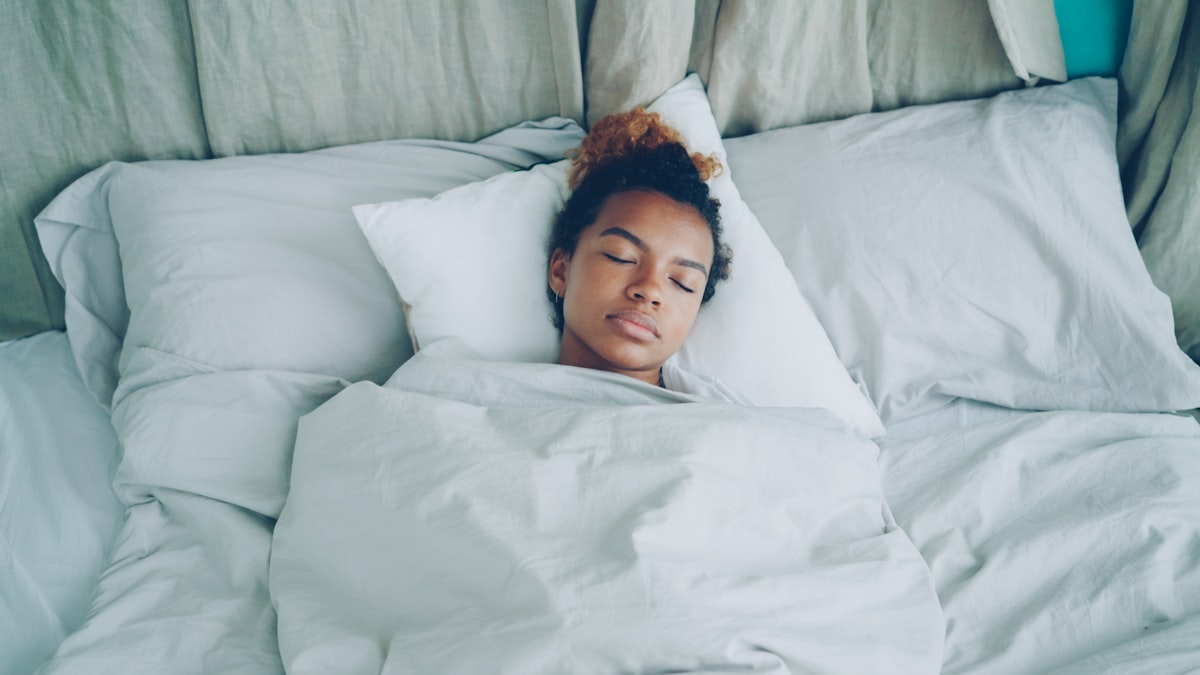 Woman sleeping peacefully in bed for muscle recovery