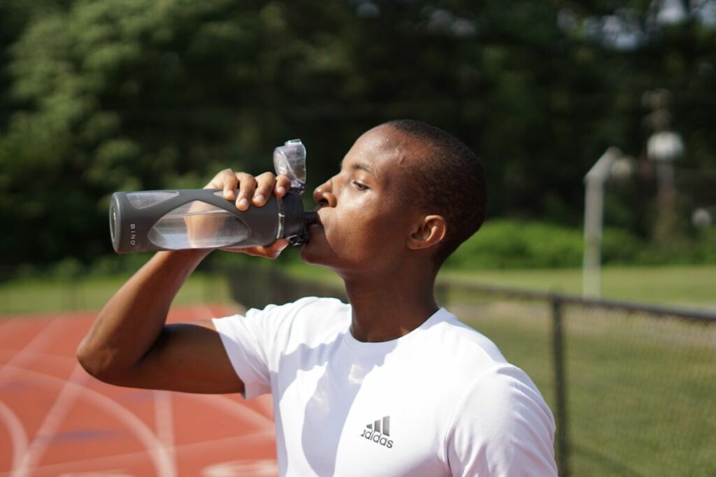 Man drinking water from sports bottle during workout - the science of hydration