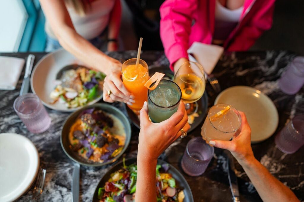 A group of friends enjoying healthy brunch choices at a wooden table outdoors
