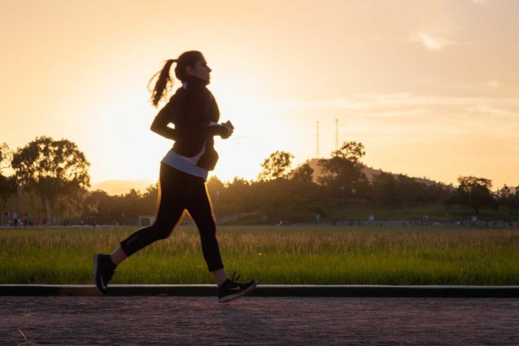 Woman running on a road at sunrise - fasted cardio - fitness friday facts