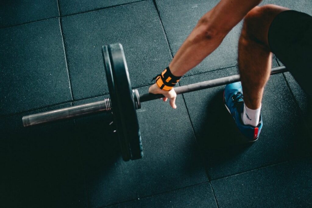 A gym member performing strength training and barbell exercises