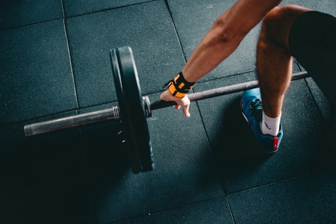 A gym member performing strength training and barbell exercises