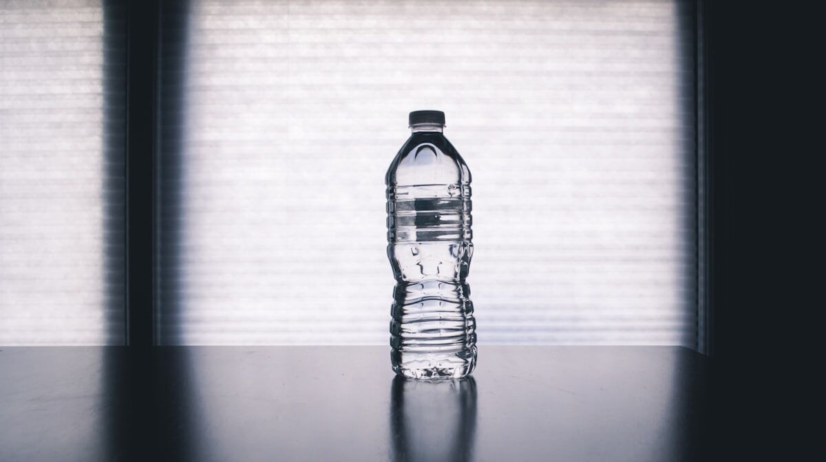 shaker water bottle on a gym floor representing hydration for recovery