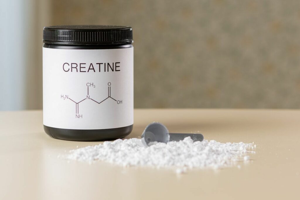 creatine for muscle growth - a jar and scoop of creatine supplement powder