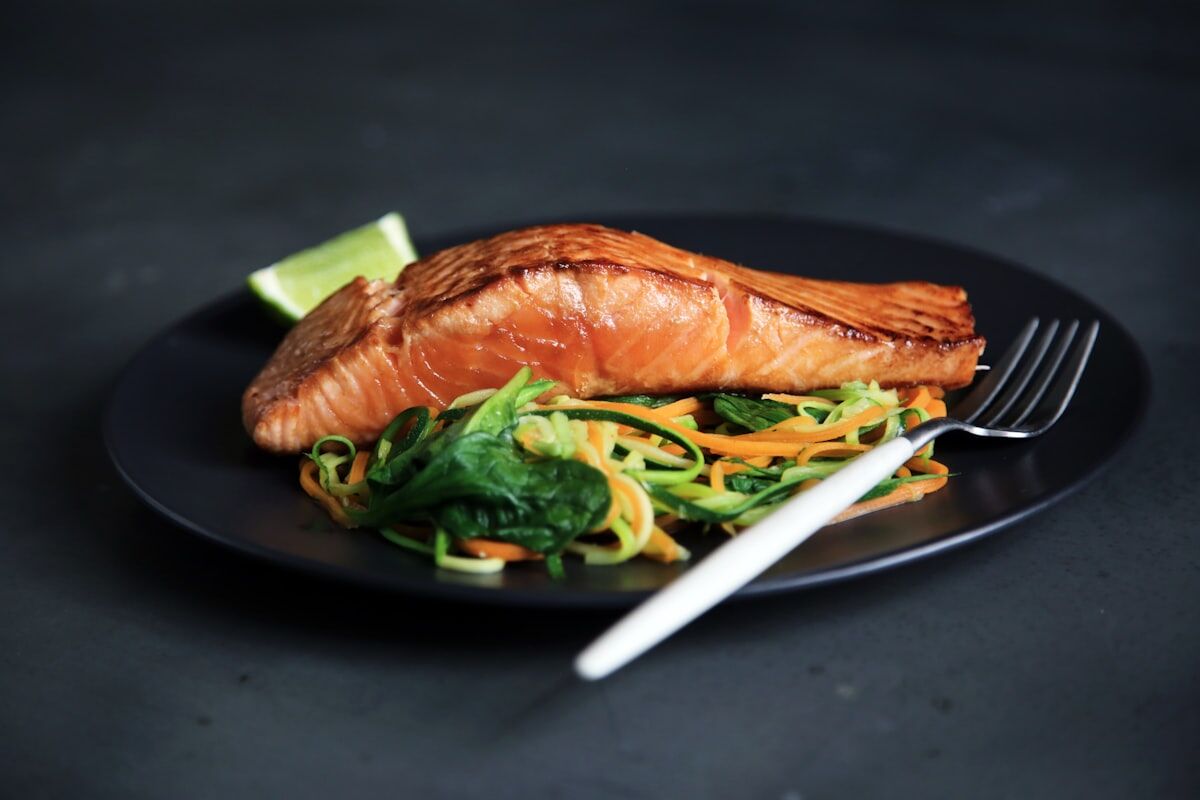 A balanced meal of grilled fish and vegetables supporting post workout nutrition.