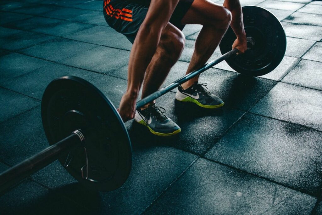 Person preparing to lift a heavy barbell - workout routine myths - fitness friday facts