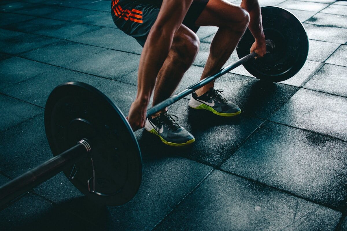 Person preparing to lift a heavy barbell - workout routine myths - fitness friday facts