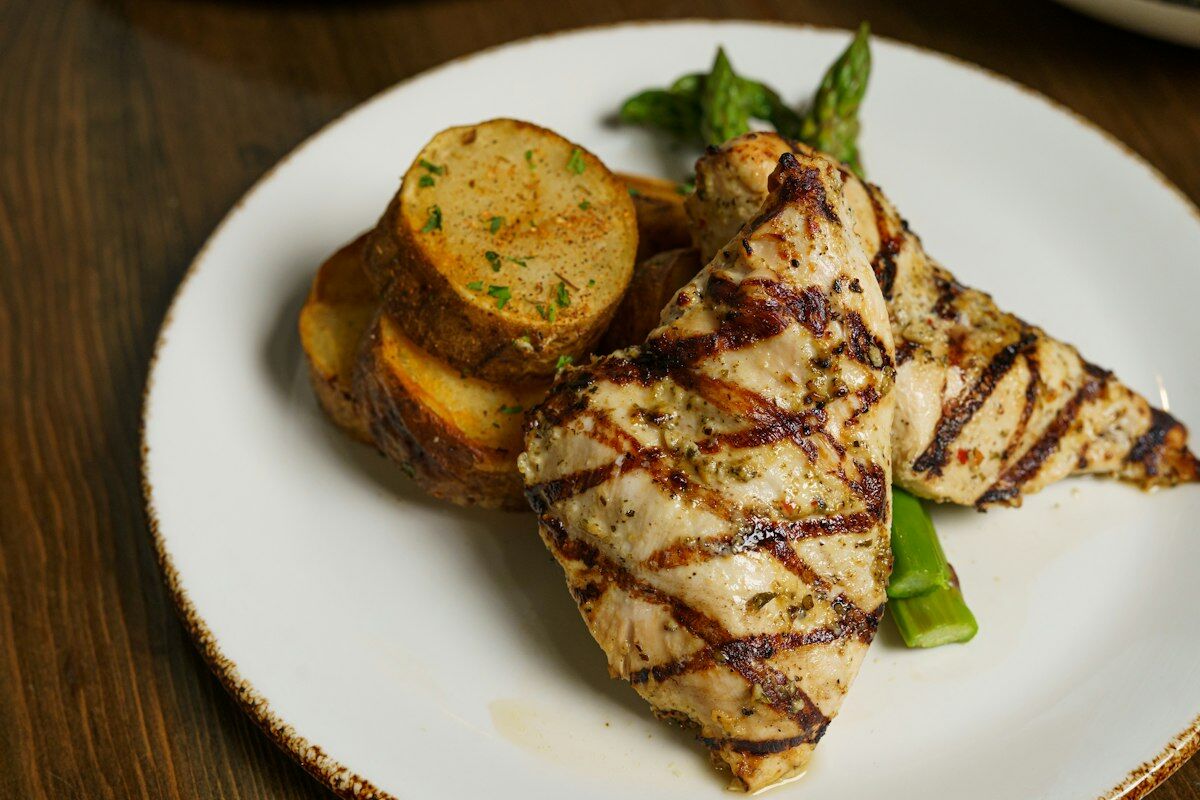protein distribution per meal - sliced grilled chicken breast with green vegetables