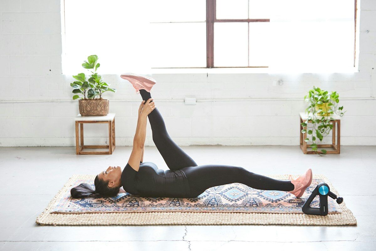 Woman stretching on floor - muscle soreness myths - fitness friday facts