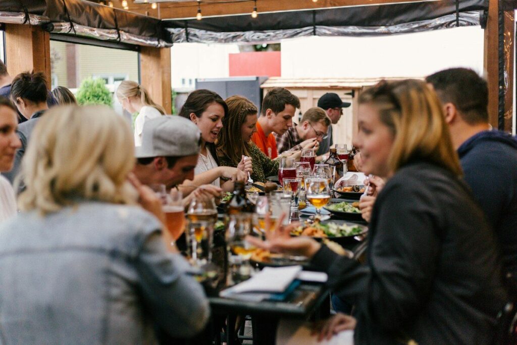 A group of friends enjoying a dinner party around a dining table - eating healthy at dinner parties