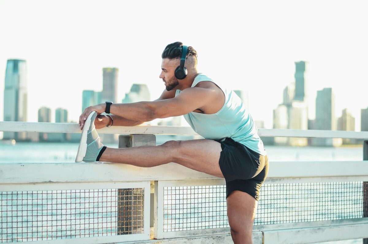 Runner stretching legs outdoors - pre-workout warmup - fitness friday facts